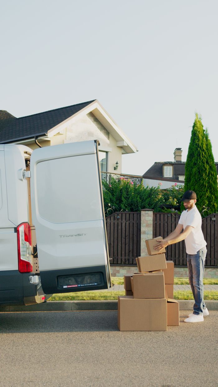 gallery-6 A delivery man organizing packages into a van outside a suburban house.
